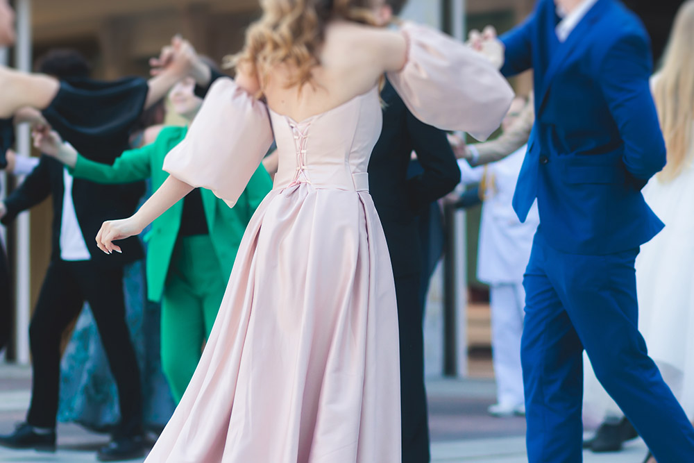 A high school prom girl dancing in a pink dress. 