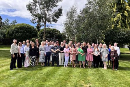 Gathering of team in gardens celebrating long service at a hotel