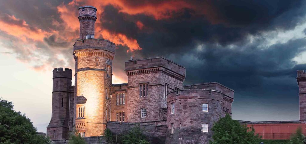 Inverness Castle at sunset with red sky behind it.